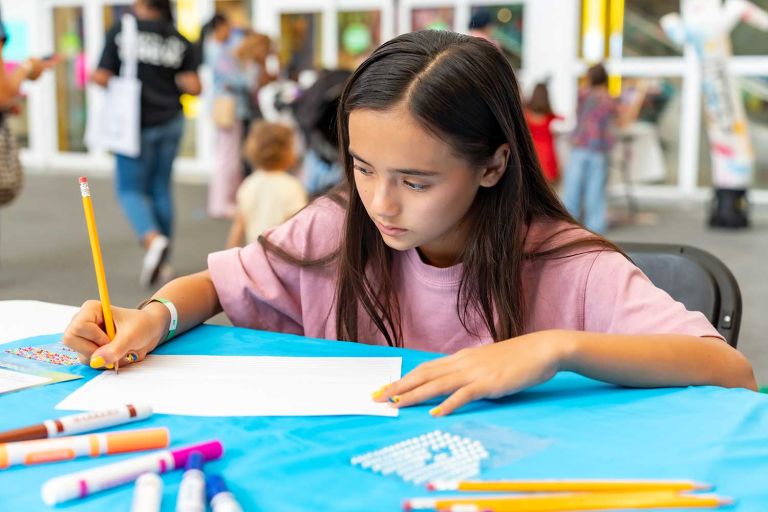 Child participating in the "What If?" Challenge at a Pop-Up Creativity Event in South Florida